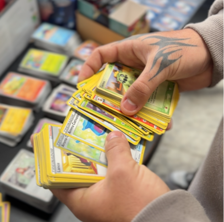 Pessoa trocando e organizando cartas Pokémon